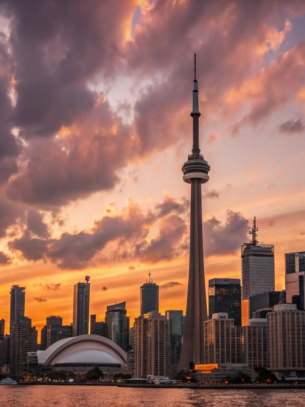 A vibrant, eye-level shot of the CN Tower's observation deck, bustling with visitors enjoying the panoramic city views during sunset.